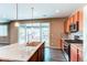 Modern kitchen features stainless steel appliances, granite counters and an island with stylish pendant lighting at 27615 E Archer Ave, Aurora, CO 80018