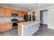 Well-lit kitchen featuring stainless steel appliances, a granite island, wooden cabinetry, and modern pendant lights at 27615 E Archer Ave, Aurora, CO 80018