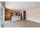 Open-concept kitchen with stainless steel appliances, granite island, wooden cabinetry, and views of living space at 27615 E Archer Ave, Aurora, CO 80018