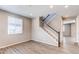 A bright living room with light-colored walls, wood floors, staircase, and windows that let in plenty of natural light at 27615 E Archer Ave, Aurora, CO 80018