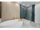 Modern bathroom featuring a soaking tub and luxurious shower with stylish blue tile and gold accents at 3035 S Indiana St, Lakewood, CO 80228