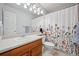 Classic bathroom featuring a vanity with storage, a toilet, and a shower with a floral curtain at 3035 S Indiana St, Lakewood, CO 80228