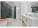 Beautiful bathroom with double sinks, modern vanity, stylish lighting, and a luxurious tiled shower at 3035 S Indiana St, Lakewood, CO 80228