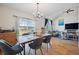 Bright dining room with hardwood floors, and view of Gathering room and neighborhood through large windows at 3035 S Indiana St, Lakewood, CO 80228