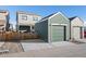 Detached garage with a green door and concrete driveway, matching the house's exterior at 1143 Hummingbird Cir, Longmont, CO 80501