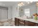 Well-lit bathroom with a double vanity, dark cabinets, a large mirror, and a shower at 12685 E 104Th Pl, Commerce City, CO 80022