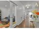 Bright hallway with hardwood floors, leading to a living room with glass doors and a dining area at 12685 E 104Th Pl, Commerce City, CO 80022