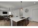 Kitchen island featuring a white countertop, dark cabinets, and a sink, with an adjacent dining area at 12685 E 104Th Pl, Commerce City, CO 80022