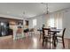 Open-concept kitchen and dining area featuring modern appliances, a breakfast bar, and hardwood floors at 12685 E 104Th Pl, Commerce City, CO 80022