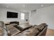 Comfortable living room with a large sectional sofa, TV, and a staircase in the background at 12685 E 104Th Pl, Commerce City, CO 80022