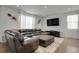 Inviting living room featuring a plush sofa, modern TV setup, and contemporary decor at 12685 E 104Th Pl, Commerce City, CO 80022