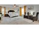 Spacious main bedroom with a king-sized bed, sitting area, large windows, and neutral carpet at 12685 E 104Th Pl, Commerce City, CO 80022