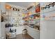 A fully stocked walk-in pantry with ample shelving containing a variety of food items and containers at 12685 E 104Th Pl, Commerce City, CO 80022