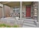 Inviting front porch with stone accents, a red door, and well-manicured landscaping at 12685 E 104Th Pl, Commerce City, CO 80022