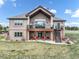 Spacious backyard with a deck, staircase, and outdoor seating area with red chairs at 17275 Gwilym Ct, Monument, CO 80132