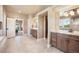 Bright bathroom featuring double sinks with granite countertops and wood cabinets plus access to main bedroom at 17275 Gwilym Ct, Monument, CO 80132