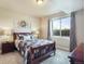 Cozy bedroom boasts a plaid comforter, side tables, and a sunny window view at 17275 Gwilym Ct, Monument, CO 80132