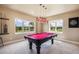 Entertaining game room with a vibrant red pool table and natural light at 17275 Gwilym Ct, Monument, CO 80132