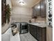 Functional laundry room with modern appliances, cabinets, folding counter, utility sink and a bench seat at 17275 Gwilym Ct, Monument, CO 80132