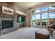 Inviting living room features a stone fireplace, large windows, plush carpet, and access to an outdoor patio at 17275 Gwilym Ct, Monument, CO 80132