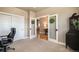 Well-lit office featuring neutral colors, plush carpet, double doors and a view into a connected living space at 17275 Gwilym Ct, Monument, CO 80132