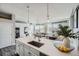 Modern kitchen features a large island with white cabinets and quartz countertops at 277 N Broadway # 208, Denver, CO 80203