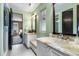 Bathroom featuring double sinks, marble countertop, and an open view to the bedroom at 235 Eudora St, Denver, CO 80220