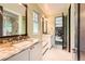 Bright bathroom featuring dual sinks with marble countertops, and a glass shower enclosure at 235 Eudora St, Denver, CO 80220
