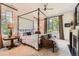 Spacious bedroom with a four-poster bed, fireplace, and large windows offering backyard views at 235 Eudora St, Denver, CO 80220