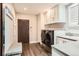 Well-lit laundry room featuring modern appliances, sleek countertops, and ample storage space at 235 Eudora St, Denver, CO 80220
