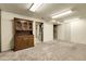 Finished basement with neutral carpet, and hutch with glass doors and drawers at 4108 S Inca St, Englewood, CO 80110
