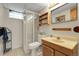 Bathroom featuring glass shower stall, mirrored vanity, and neutral tile flooring at 4108 S Inca St, Englewood, CO 80110