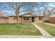 Charming brick home with a well-manicured lawn, inviting walkway, and a cozy front porch bench at 4108 S Inca St, Englewood, CO 80110