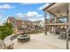 Spacious backyard featuring a stone fire pit, an upper deck with outdoor seating, and a lower patio with a hot tub at 8783 S Winnipeg Ct, Aurora, CO 80016