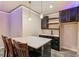 Charming basement bar featuring quartz counters, pendant lighting, dark wood cabinetry, and a stylish, functional design at 8783 S Winnipeg Ct, Aurora, CO 80016