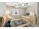 Cozy bedroom featuring neutral paint, a window, wood-look floors, and simple wooden furniture with a full dresser at 8783 S Winnipeg Ct, Aurora, CO 80016