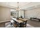 Elegant dining room with modern lighting, a stone accent wall, and a large wooden table with bench seating at 8783 S Winnipeg Ct, Aurora, CO 80016