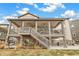 Rear exterior of the house showing the stone foundation and stairs leading to an outdoor seating area on the second floor at 8783 S Winnipeg Ct, Aurora, CO 80016