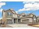 Beautiful two-story home with a three-car garage, gray siding, stone accents, and solar panels on the roof at 8783 S Winnipeg Ct, Aurora, CO 80016