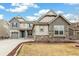 Two-story home with a three-car garage, gray siding, a stone foundation, and a manicured front lawn at 8783 S Winnipeg Ct, Aurora, CO 80016