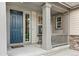 Inviting front porch featuring a blue front door, gray pillars, and stylish decor at 8783 S Winnipeg Ct, Aurora, CO 80016