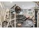 Home gym boasts a full array of weight-lifting equipment, weights, mirrors, rubber flooring, and a TV screen at 8783 S Winnipeg Ct, Aurora, CO 80016
