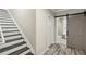 Hallway with gray wood floors, stairs, a standard door and gray barn door to a bathroom at 8783 S Winnipeg Ct, Aurora, CO 80016