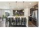 Contemporary kitchen featuring a large island with seating, dark cabinets, and stainless steel appliances at 8783 S Winnipeg Ct, Aurora, CO 80016