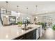 Bright, open kitchen with a large island, pendant lighting, and views of the living area at 8783 S Winnipeg Ct, Aurora, CO 80016