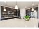 Modern kitchen with dark cabinets, stainless steel appliances, quartz countertops, and a large island at 8783 S Winnipeg Ct, Aurora, CO 80016