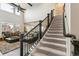 Carpeted staircase with dark wood accents leads to the second story of this home at 8783 S Winnipeg Ct, Aurora, CO 80016