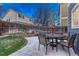 Fenced backyard with stone patio, seating and an umbrella ready for outdoor entertaining at 7412 S Mobile St, Aurora, CO 80016