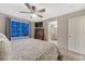 Bedroom with ceiling fan, TV, large window and view to attached bathroom at 7412 S Mobile St, Aurora, CO 80016
