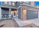 Close up shot of a home with a charming covered front porch and a two car attached garage at 7412 S Mobile St, Aurora, CO 80016